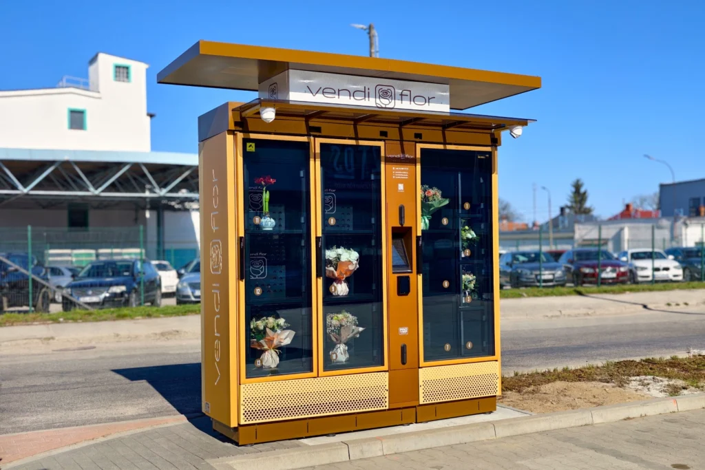 VendiFlor flower vending machine in gold color located in Bolesławiec, displaying fresh bouquets behind glass doors